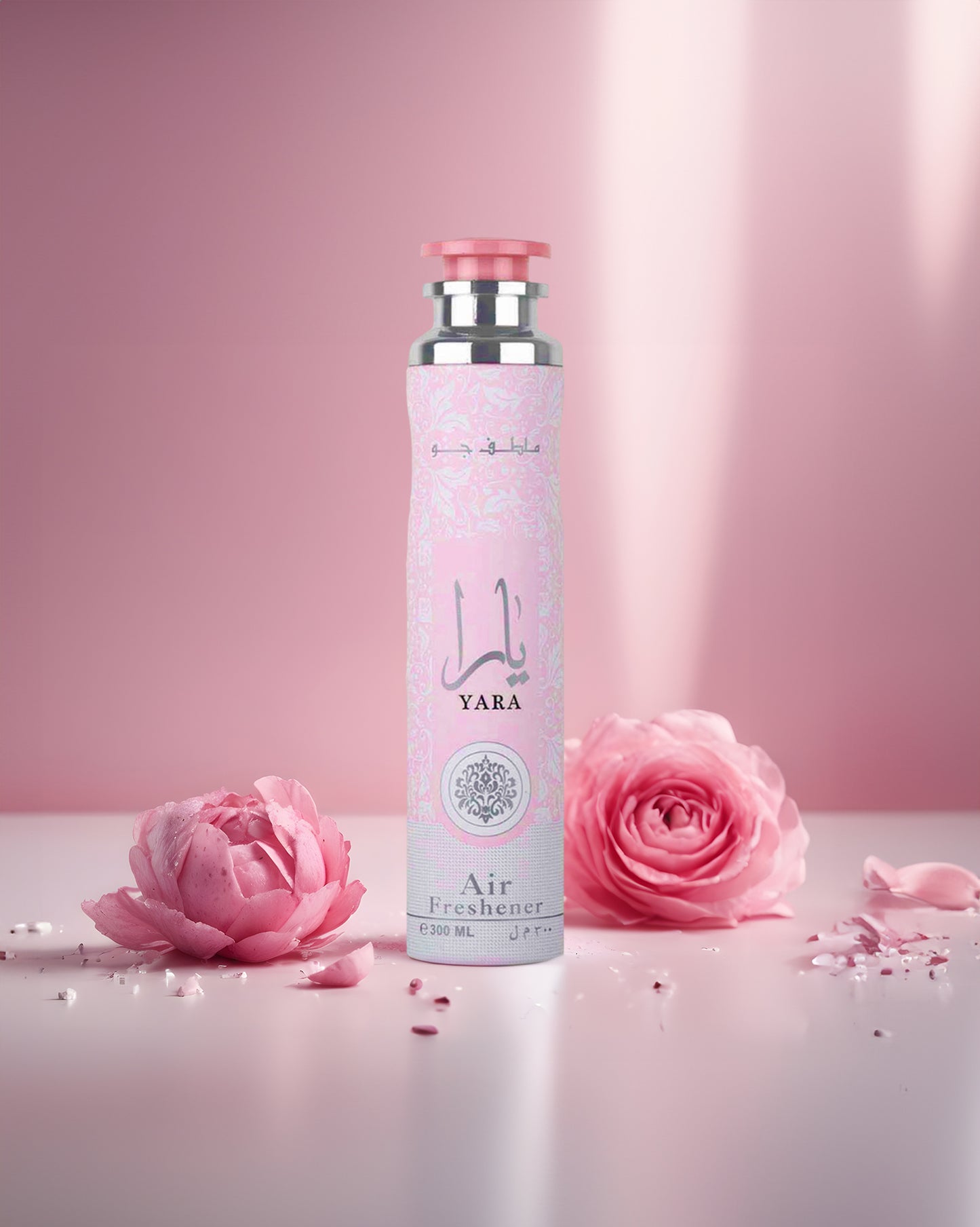 Yara AIR FRESHNER BOTTLE surrounded by roses against pink background with sunlight