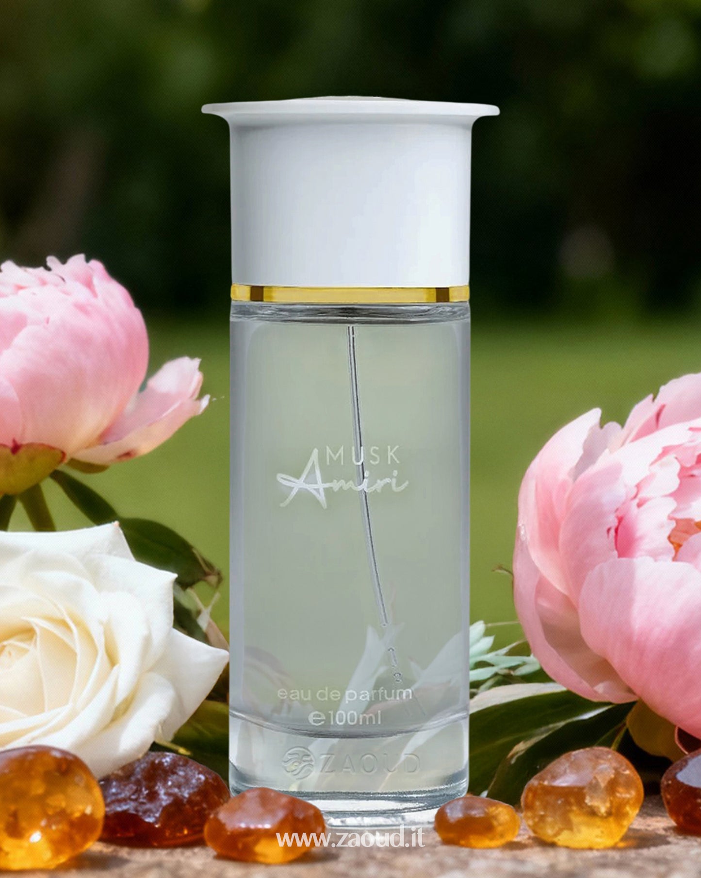 Ahmed Al Maghribi Musk Amiri Perfume bottle positioned outdoors among pink peonies and a white rose. The base of the bottle is surrounded by small, amber-colored resinous stones. The background is a soft-focus greenery.