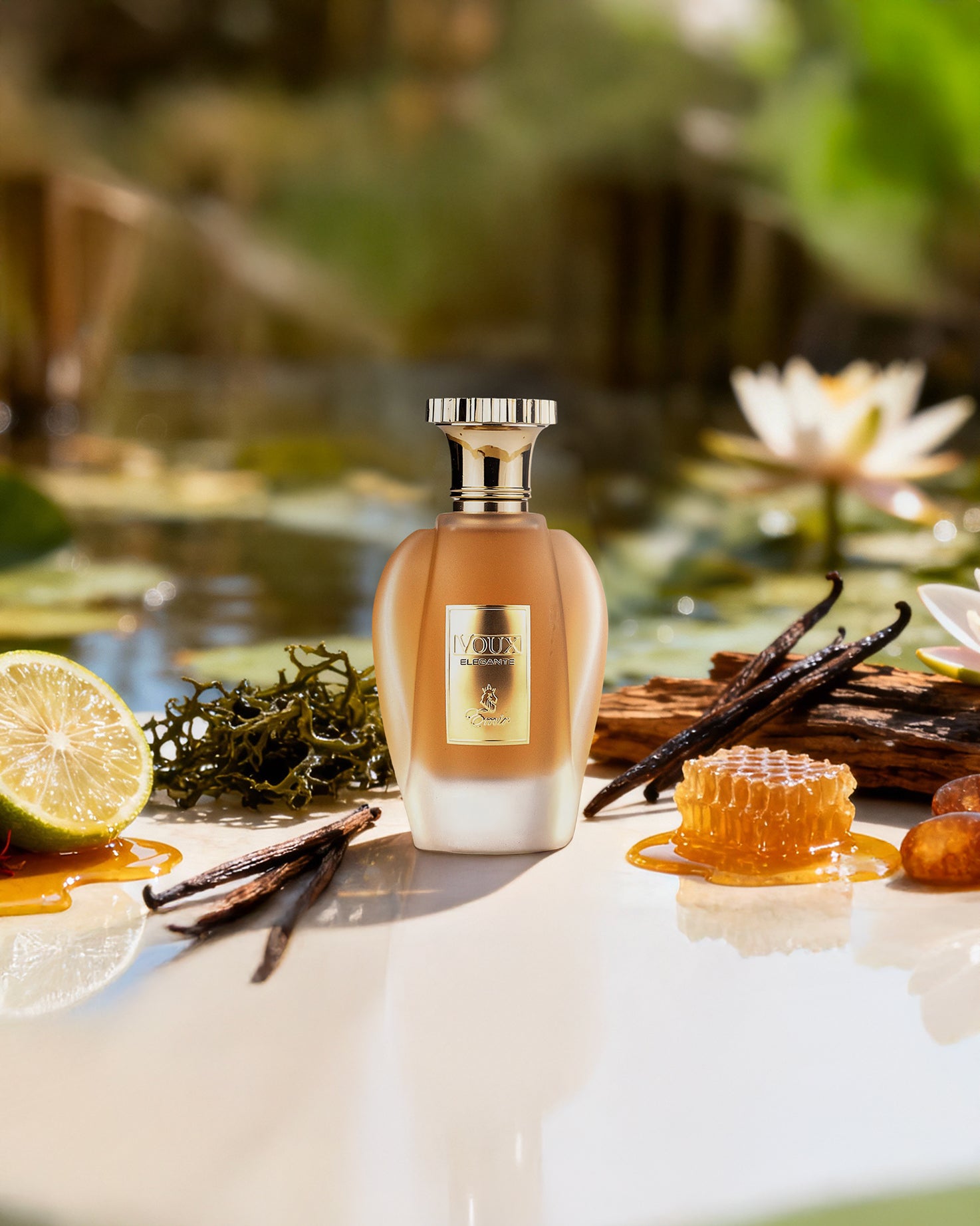 emir voux elegante Perfume bottle with vanilla beans, lime, and flowers on a reflective surface