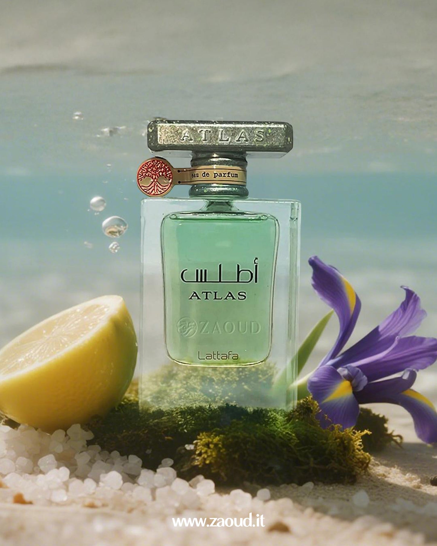 Atlas perfume bottle with a lemon and purple flower on a beach setting