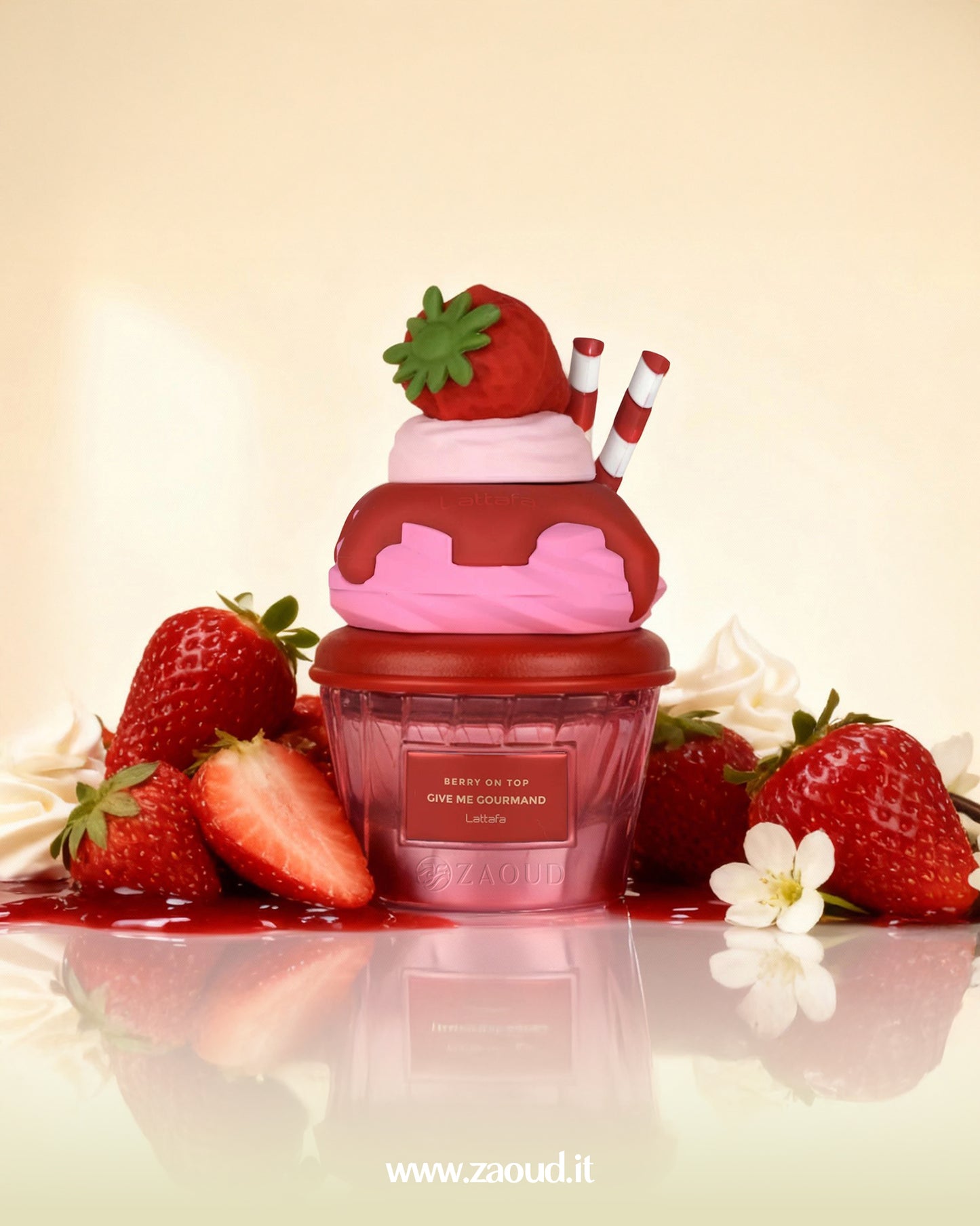 Lattafa "Berry on Top Give Me Gourmand" perfume bottle, which is shaped like a pink and red ice cream sundae with a strawberry on top. Fresh strawberries and whipped cream are scattered around the base.