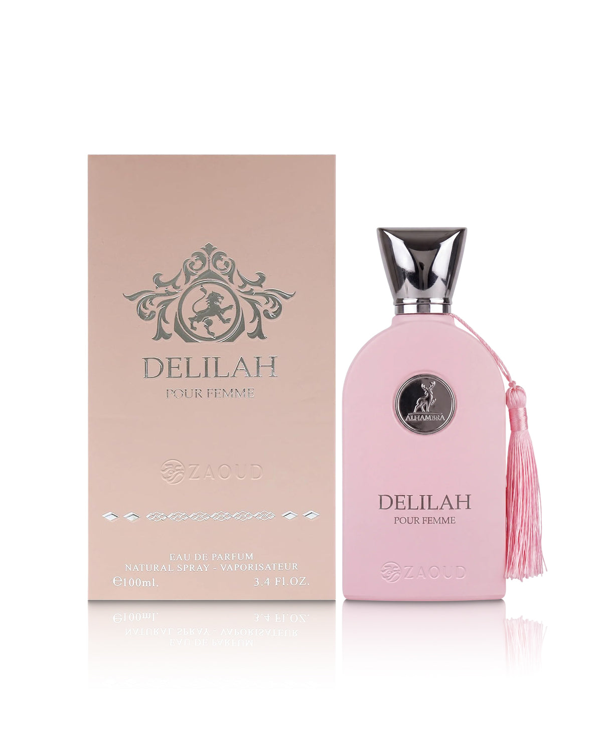 A pink Delilah pour femme Parfum bottle with a silver cap and a pink tassel, displayed next to its matching pink packaging box on a reflective white surface.