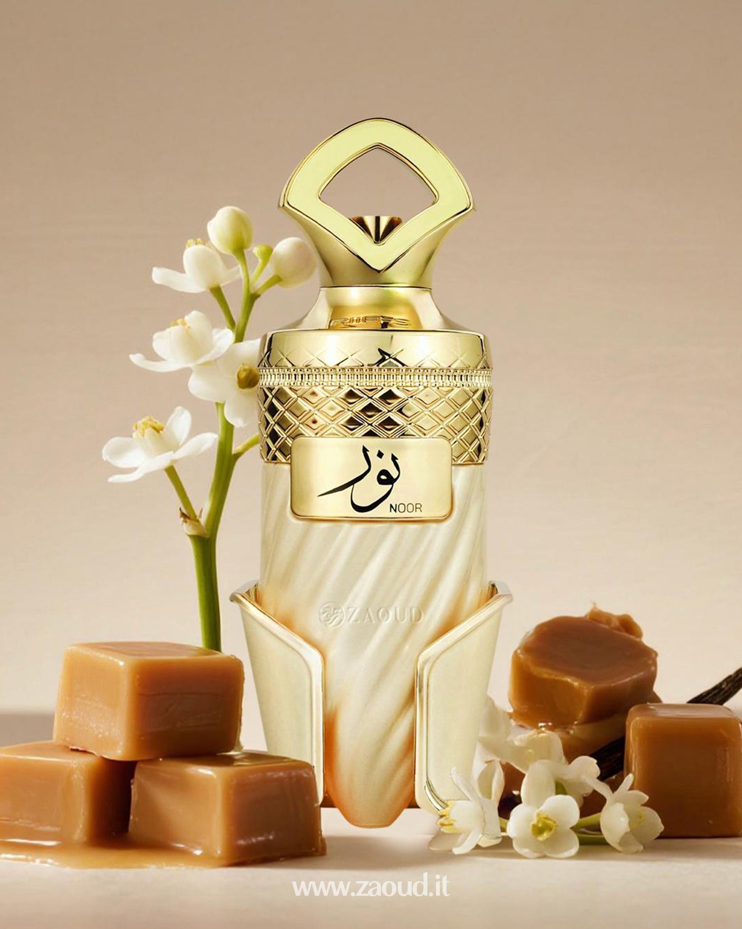 Noor perfume by Riffs in a golden and ivory design, surrounded by caramel cubes, vanilla pods, and delicate white jasmine flowers, placed on a beige background