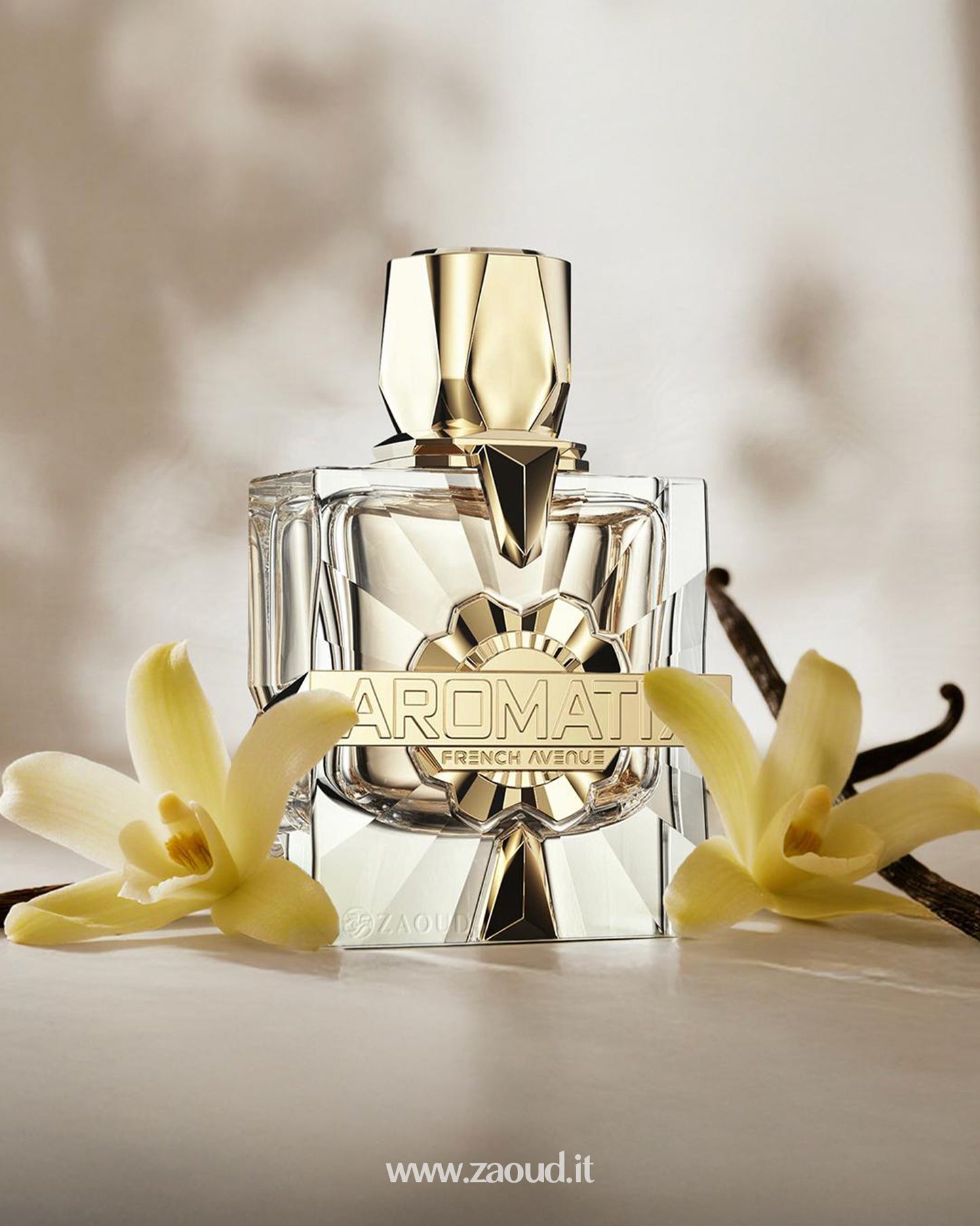 FRENCH AVENUE AROMATIX X-XANDAL Extrait de parfum bottle, surrounded by fresh vanilla flowers and vanilla pods on a soft beige background.