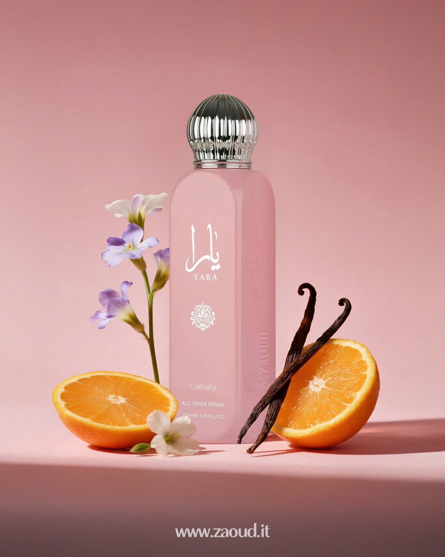 Lattafa Yara All Over Spray, surrounded by orange slices, vanilla sticks, and purple flowers. The background is a soft pink color.