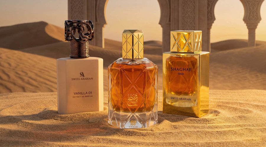 Luxury Arabic perfumes displayed in desert setting – Swiss Arabian Vanilla 01, Ahmed fragrance bottle, and Shaghaf Oud by Swiss Arabian with golden Arabian architecture background.