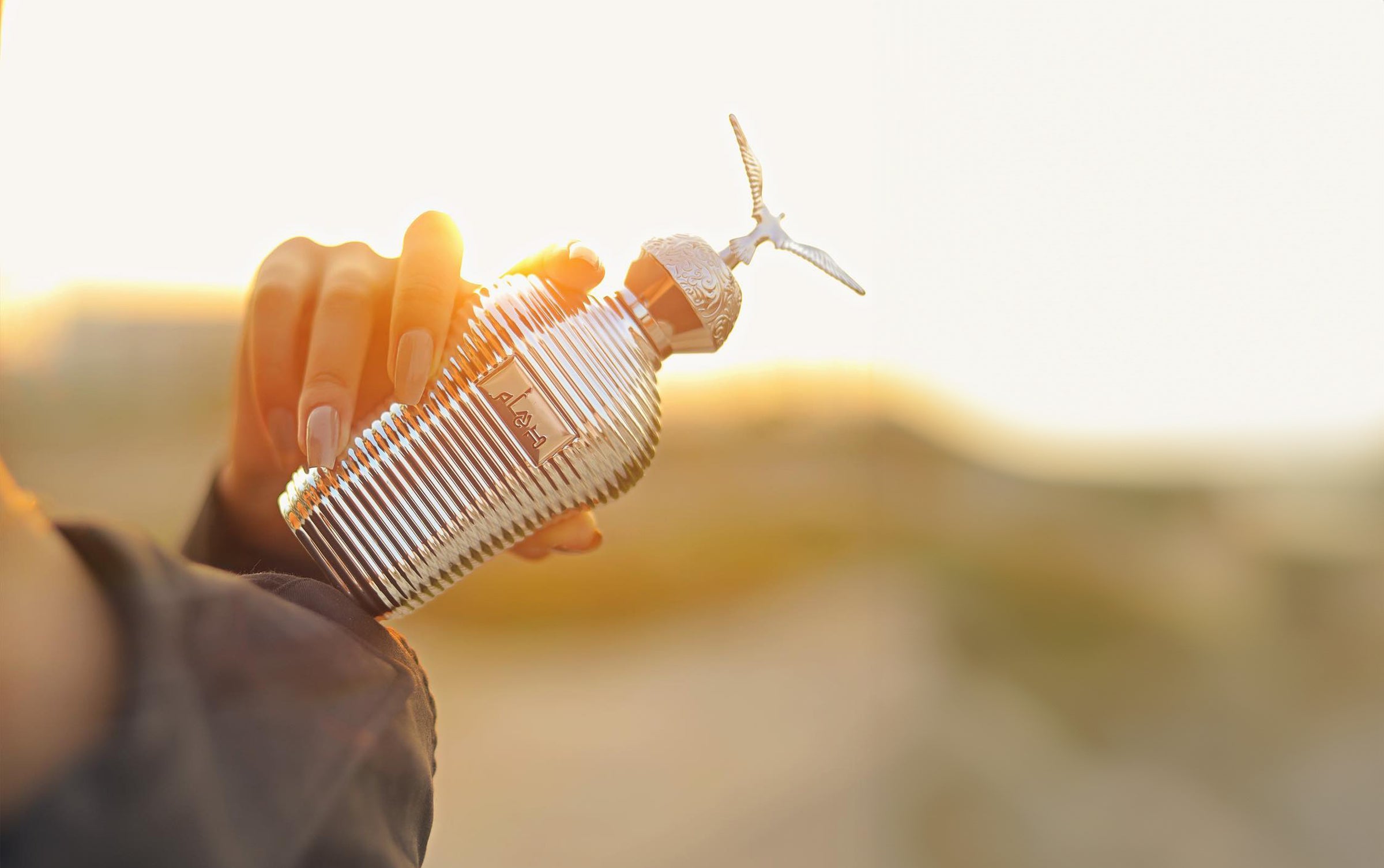maison asrar alonoud perfume bottle against sunset.