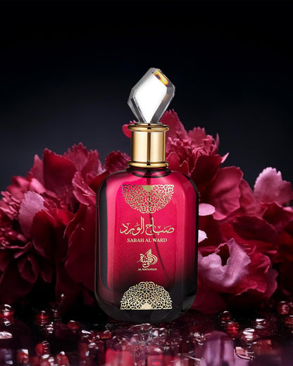 al wataniah sabah al ward perfume bottle phtograph over reflected surface against red roses at background.