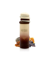 Macaron-shaped container with arabiyat sugar Caramel Chocolate Macaron perfume bottle surrounded by caramel and tonka beans on a white background