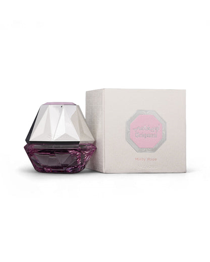 athoor al alam origami misty rose Purple perfume bottle with hexagonal design next to its packaging on a white background