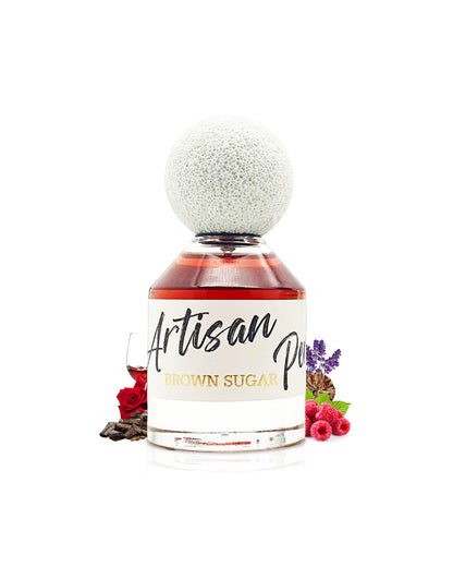 FRAGRANCE WORLD brown sugar Artisan Perfumery perfume bottle surrounded with fragrance notes like rose and raspberry shows against white background