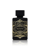 lattafa badee al oud oud for glory perfume bottle with a black cap, featuring an ornate gold geometric label with Arabic and English text, set against a clean white background with a soft reflection below.