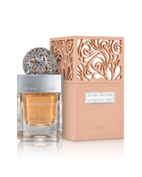 A bottle of lattafa Beyond Precious perfume with a silver cap and ornate silver top, next to its peach-colored box with intricate cutout patterns, on a white background.