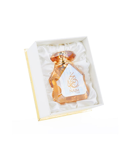 najm gold perfume oil bottle shows from beside the luxurious box against white background