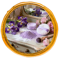 Cosmetic set with purple powder, jar, and bath bomb on a decorative surface with flowers.