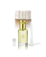 qahwa perfume oil bottle beside roller and stick with khamrah qahwa bottle behind against white background