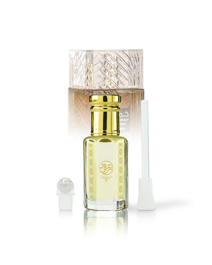 qahwa perfume oil bottle beside roller and stick with khamrah qahwa bottle behind against white background