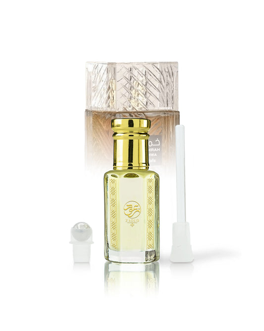 qahwa perfume oil bottle beside roller and stick with khamrah qahwa bottle behind against white background