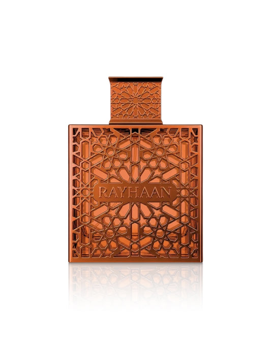 Rayhaan vantage perfume bottle in a warm copper-orange tone with intricate geometric cutout patterns and the brand name 'RAYHAAN' embossed on the front, centered on a white background with a soft reflection below.