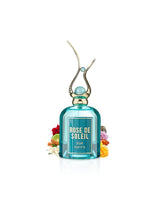 Rose de Soleil perfume bottle with decorative elements like mango and jasmine on a white background