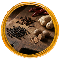 Spices including black pepper, cloves, and ginger on a wooden surface with a wooden frame.