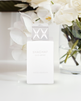 shaghaf oud abyad by swiss arabian perfume bottle phottograph over white surface against some white flowers