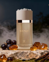 ahmed al maghribi moonlit perfume bottle photograph beside amber stones and Black Currants with smoke at background at night.
