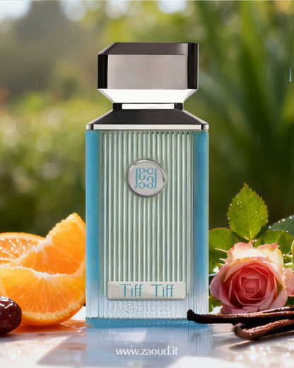 ahmed al maghribi tiff tiff Perfume bottle over reflected surface with oranges, roses, and vanilla beans on a blurred green background