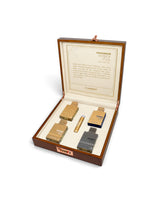 al haramain amber oud collection gift set open wooden presentation box on a white background, containing four small perfume bottles and a cylindrical tube. The inside lid has printed text and a gold crest.