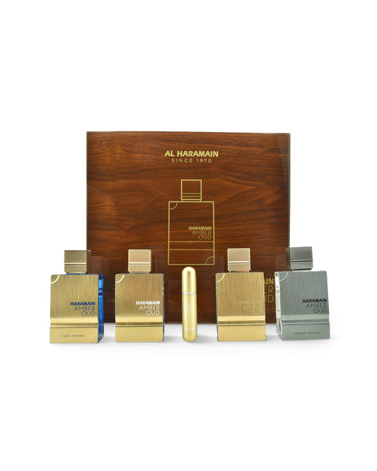al haramain amber oud collection gift set fragrance gift set featuring five small perfume bottles in gold, silver, and blue tones arranged in front of a wooden presentation box on a white background.