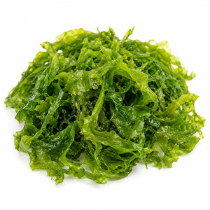 A pile of fresh green algae slices on a plain white background.