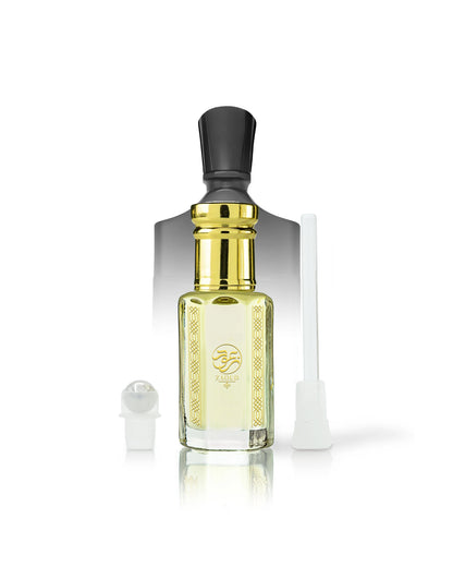 ananas absolu perfume oil bottle with pale yellow liquid, a shiny gold neck, a black cap, and a gold logo on the front. A small white spray atomizer and a white applicator tube are placed beside it on a clean white background.