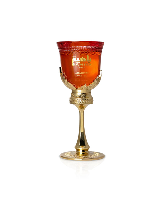 arabiyat prestige Bahiya ruby Decorative glass goblet with gold base and red glass, featuring a brand name on a white background.
