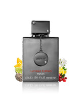 Armaf Club de Nuit Intense Man Limited Edition perfume bottle in a dark metallic gray finish, styled with citrus, berries, and white flowers on a white background with a reflection.