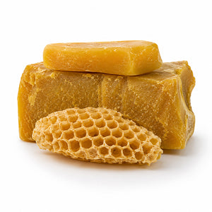 A stack of golden yellow beeswax bars with a honeycomb piece in front, photographed on a clean white background.