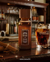 Brown bottle labeled 'Tabac N Coke' on a bar counter with a glass of Coca-Cola.