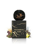 french avenue moonstone noire perfume bottle surrounded by fragrance notes like vanilla and pine shows against white background