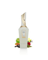 A bottle of french avenue spirito mystic perfume with a white body and a gold cap, styled with botanical ingredients like a lime, carrots, and vanilla on a white background.