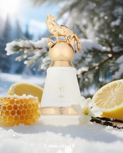 Fierte Luna by French Avenue, topped with a golden fox figurine, set in a snowy scene with lemon slices, a honeycomb, vanilla beans, and a white flower.