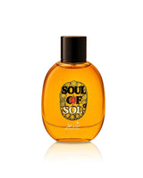 Soul of Sol by hekayat attar, featuring a translucent amber-orange glass bottle with a black cap and a decorative gold and black label, set against a plain white background with a soft reflection.