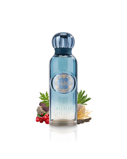imperial valley by gissah perfume bottle surrounded with its ingredients like oud and ambergris with many others shows from behind the bottle against white background
