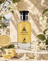 Bottle of Jean Lowe summer vibes perfume with lemons and flowers on a stone surface
