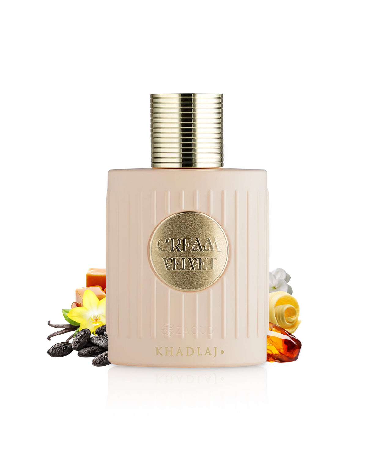 A bottle of Khadlaj Cream Velvet perfume with a pale pink ribbed body and a gold cap, styled with scent ingredients like vanilla, amber, and citrus on a white background.