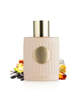 A bottle of Khadlaj Cream Velvet perfume with a pale pink ribbed body and a gold cap, styled with scent ingredients like vanilla, amber, and citrus on a white background.