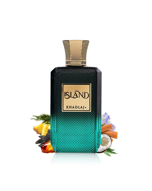 A rectangular perfume bottle labeled KHADLAJ ISLAND, with a black-to-teal gradient textured body and a gold cap, styled with tropical ingredients like lemongrass, citrus, cinnamon, and a coconut on a white background.