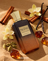 Khadlaj Island Vanilla Dunes perfume is placed on sand, surrounded by vanilla, amber stones, cardamoms, and cinnamon.
