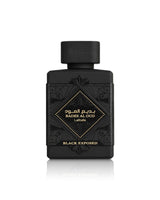 A black rectangular perfume bottle with a matching black cap, featuring gold Arabic and English lettering that reads lattafa badee al oud black exposed, set against a plain white background with a subtle reflection below.