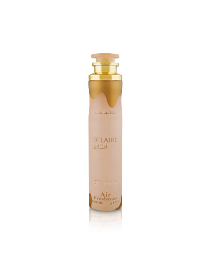lattafa Eclaire Air freshener Mist with a frosted pale pink body, gold cap, and gold dripping accent design near the top, shown on a clean white background with a soft reflection.