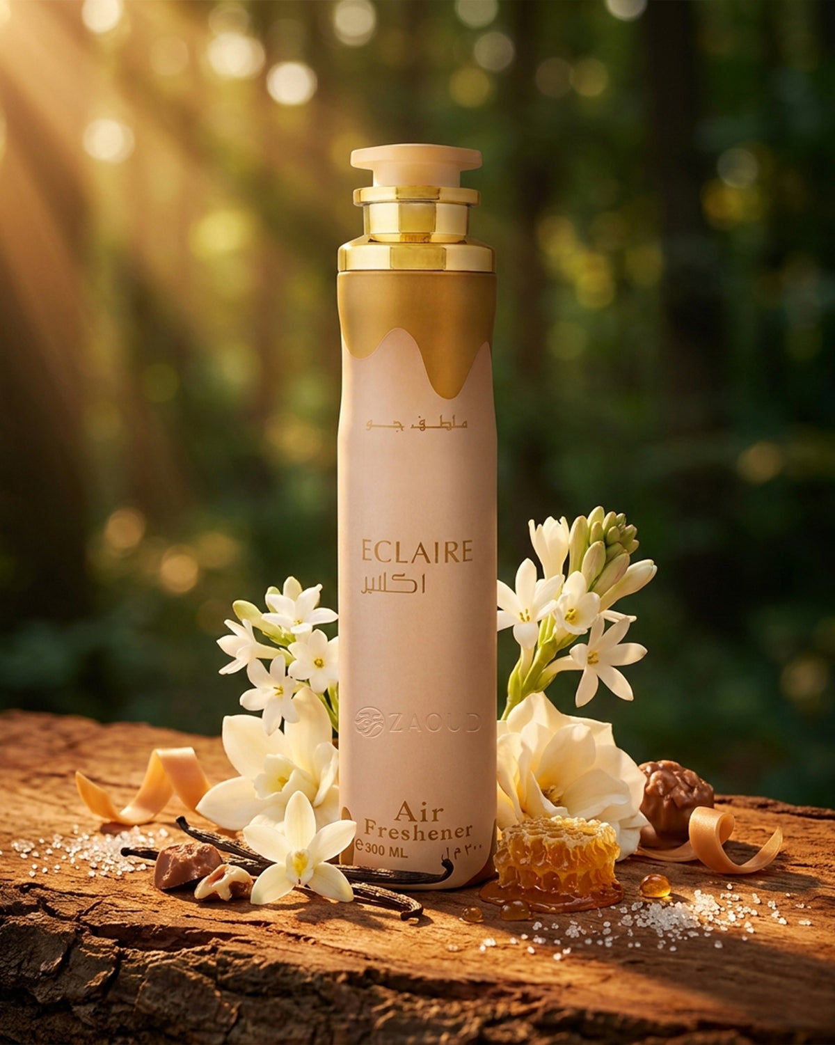 lattafa Eclaire Air freshener bottle stands on a rustic wooden surface outdoors, surrounded by white flowers, a small piece of honeycomb, and scattered petals. The bottle is cream and gold with a gold cap, and the background is a softly blurred forest scene with warm sunlight.