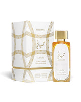 Lattafa Hayaati Gold Elixir Parfum bottle next to its white and gold patterned packaging box, on a clean white background.
